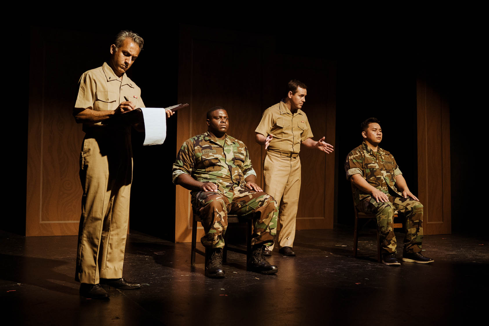 Two Marines seated for questioning while the lawyers take notes