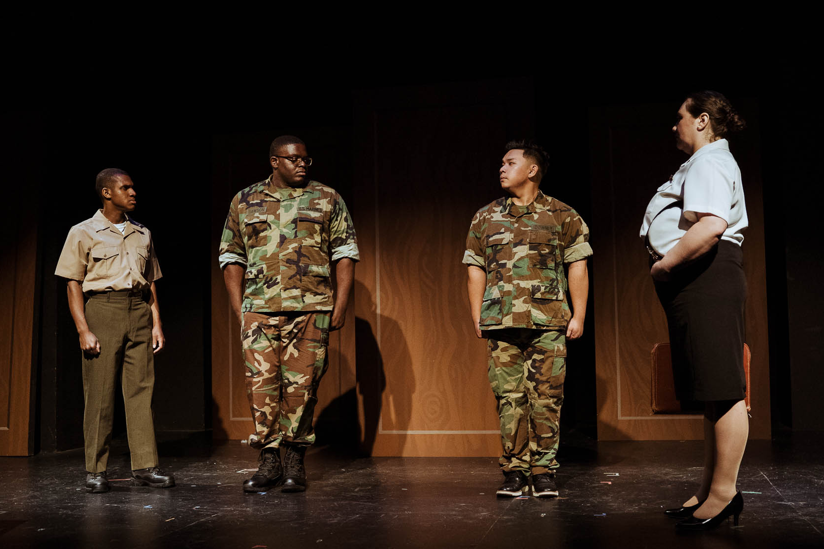 Three Marines standing in a line as an officer faces them